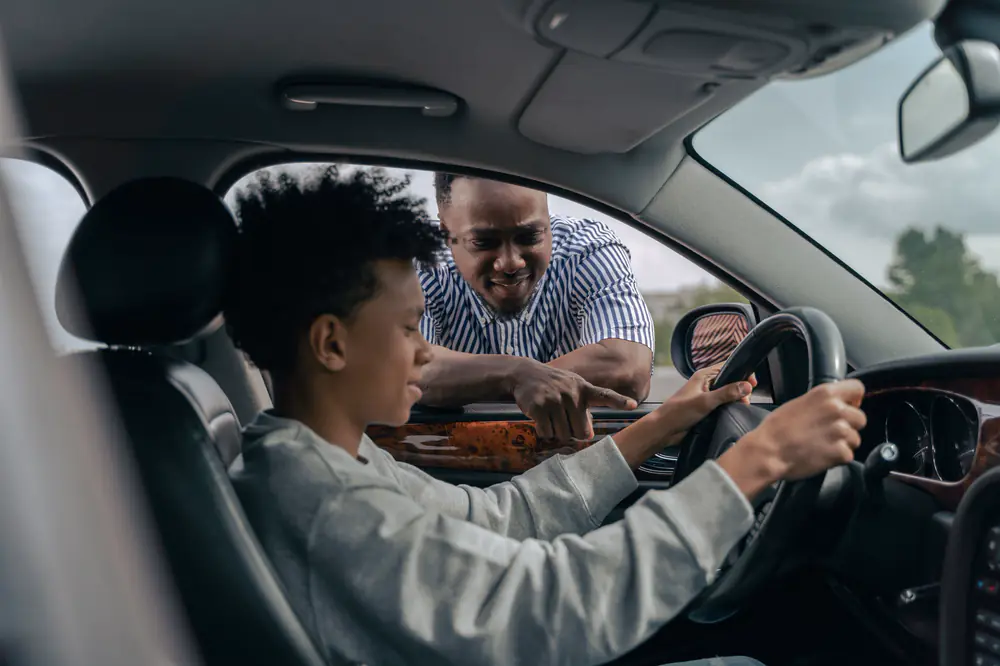 Une élève au volant, son moniteur à la portière